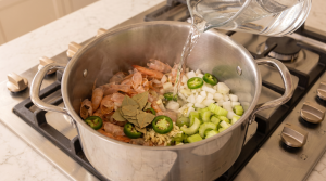 veggies chopped in saucepan with water being poured over